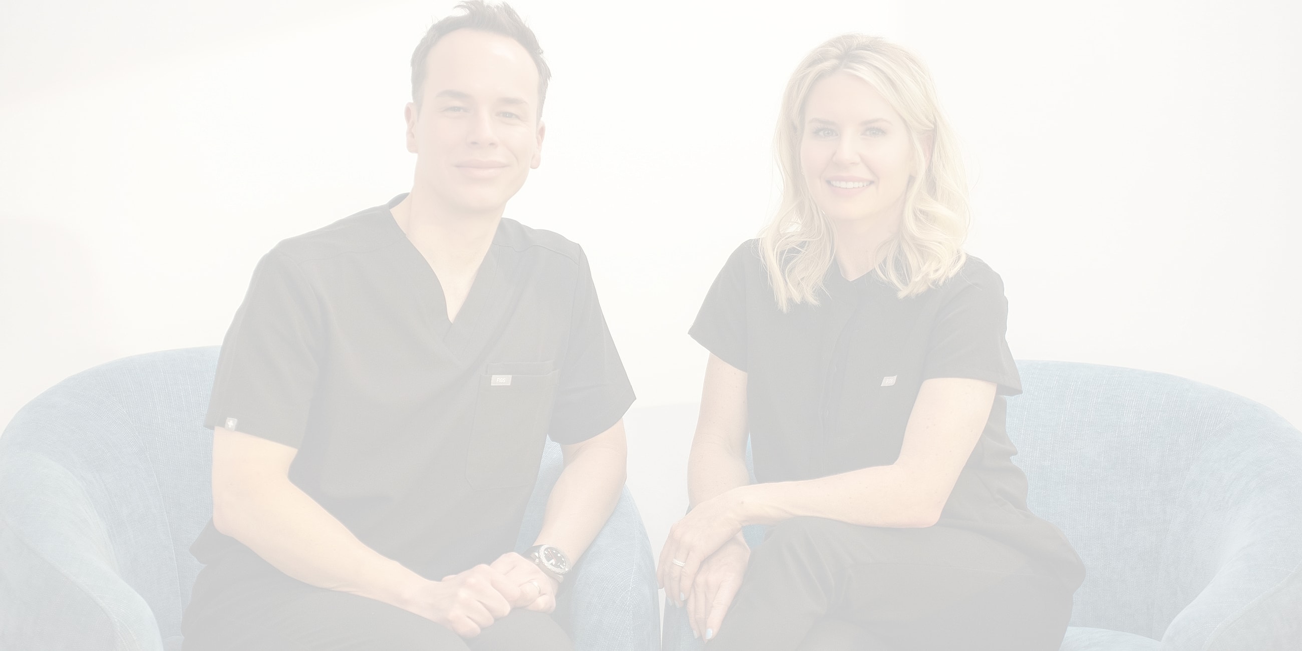 Two professionals sitting together in scrubs