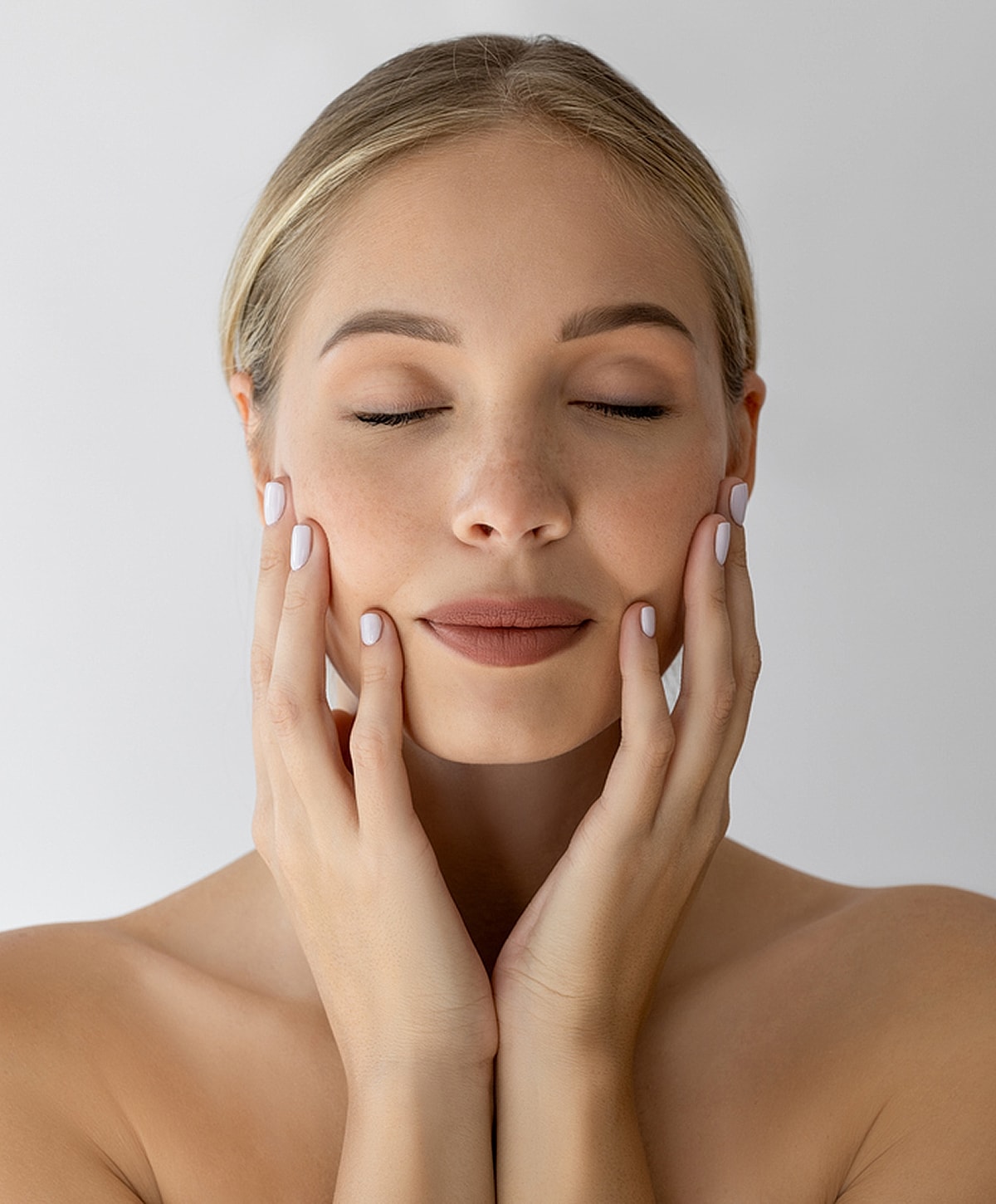 Woman with closed eyes touching her face.